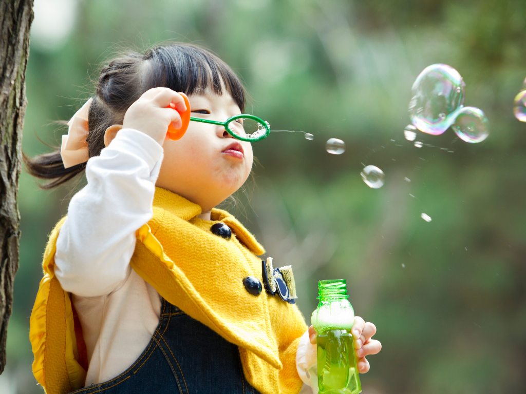child blowing bubbles
