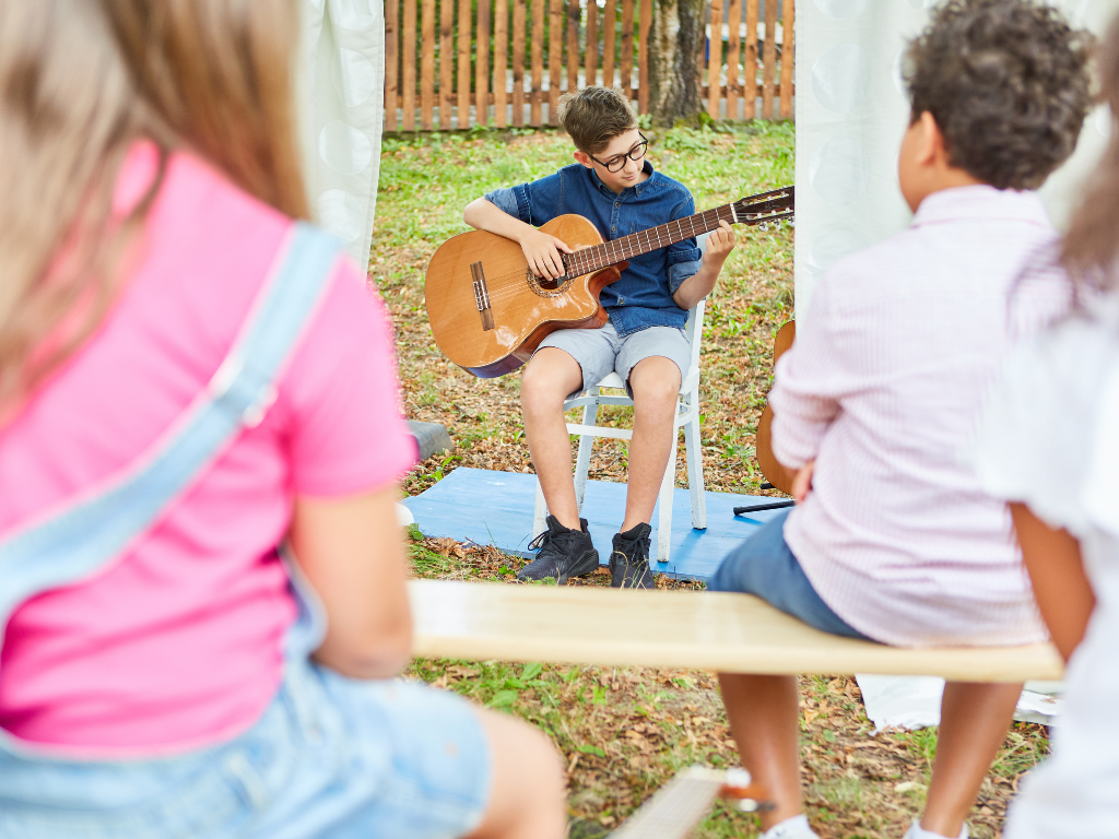 kid performing guitar at talent show